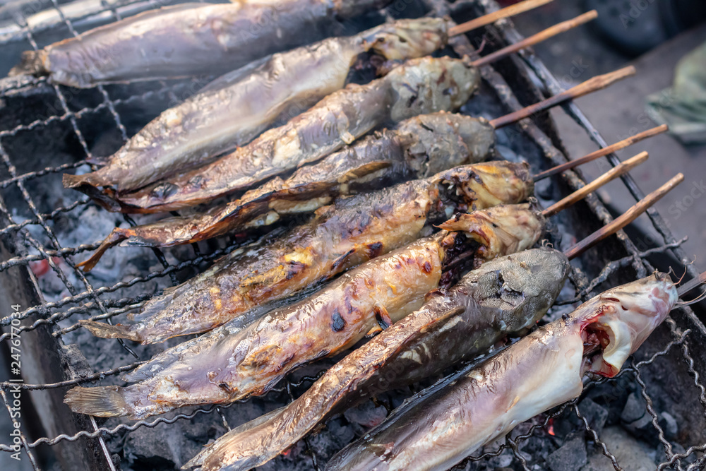 Catfish grilled on a charcoal stove.
