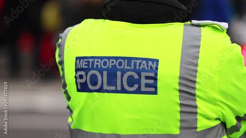 Close up of a London Metropolitan Police officer wearing a high visibility jacket photo
