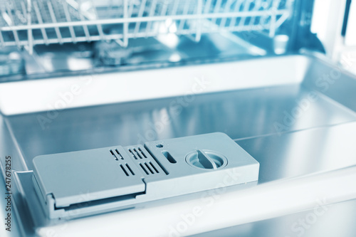 Detail of empty dishwasher with detergent dispensers, no people