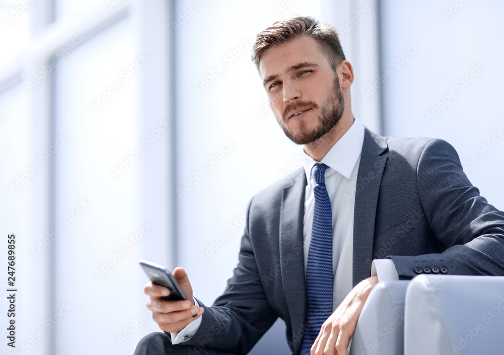 businessman sitting in an armchair with phone businessman sitting in an armchair with phone