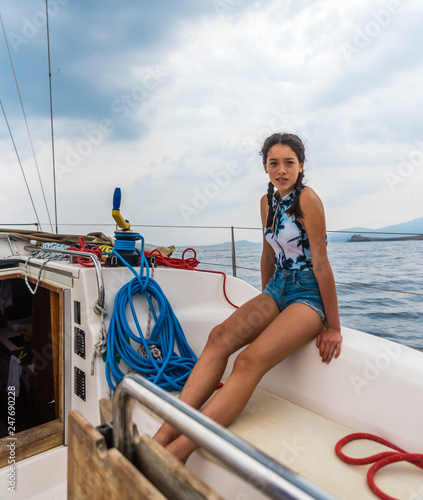 Young teen sitting on a sailboat © David