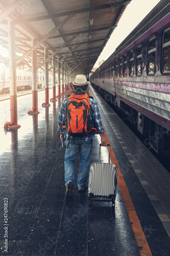 Asian traveler man with belongings waiting for travel by train