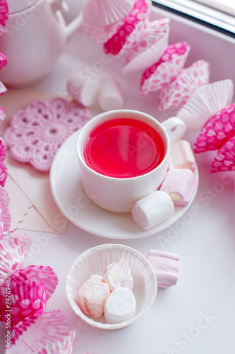 Pink breakfast of kawaii japanese girl - scented herbal tea in white cup, candy pink decor, marsmallow sweets, pretty morning tea party