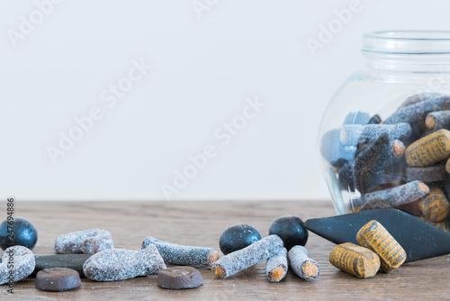 Close-up of assorted salmiakki on table and in candy jar photo