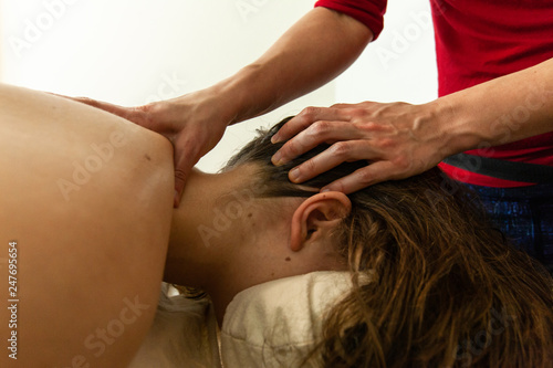 Woman's hands giving a massage. Close up of woman's hands massaging the neck of a woman, in a professional environment