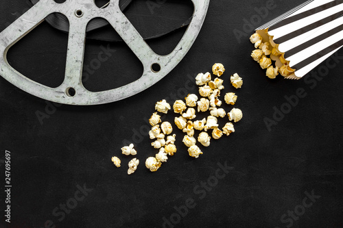 Cinema concept. film stock and popcorn on black background copy space photo