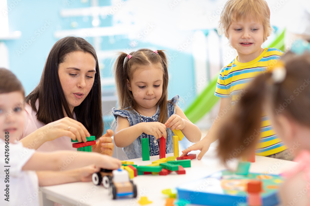 Little kids build block toys at playschool or day care center. Kids playing with color blocks. Educational toys for preschool and kindergarten children. Little kids build block toys at playschool or day care center. Kids playing with color blocks. Educational toys for preschool and kindergarten children.