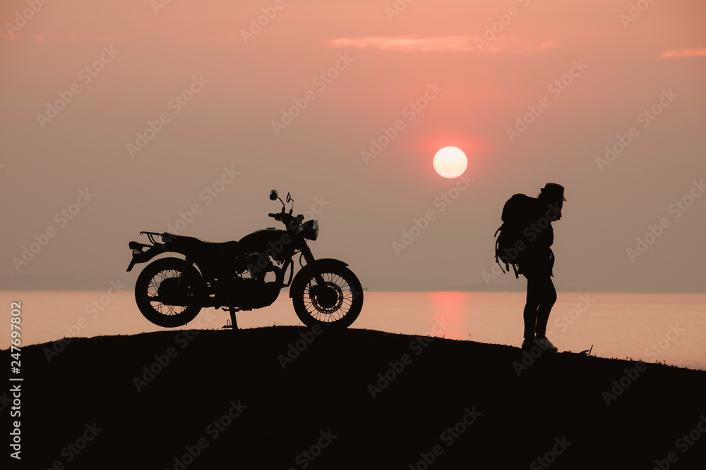 Silhouette of backpacker with Motorbike during sunrise or sunset,Beautiful sunset background, nature tourism concept Silhouette of backpacker with Motorbike during sunrise or sunset,Beautiful sunset background, nature tourism concept