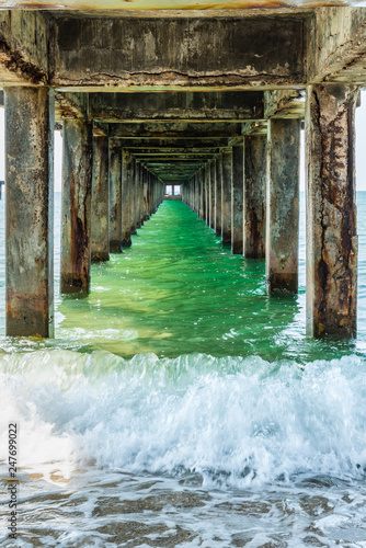 Splashing sea wave under the old concrete bridge, a bridge is pier for fishing boat and other anchored