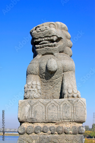 stone lion on bridge railing, China