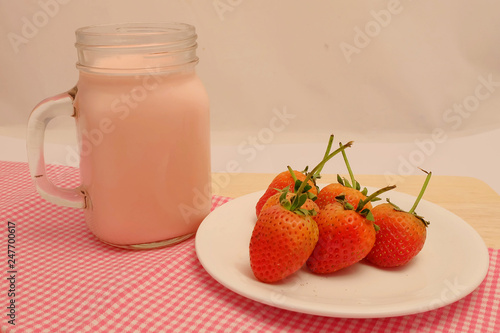 Strawberry and milk straberry flavoron wood table, sweet romantic fruit for special person in special days, lovers in Valentine day, make many dessert menu or juice or dairy strawberry flavor