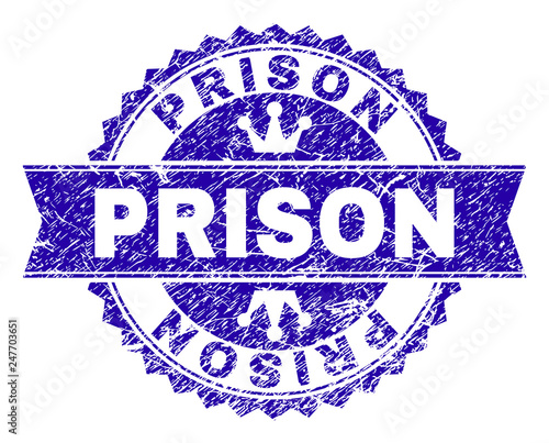 PRISON rosette seal overlay with distress texture. Designed with round rosette, ribbon and small crowns. Blue vector rubber watermark of PRISON label with scratched texture.