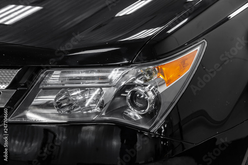 Headlamp of black american car with yellow turnlight and lens