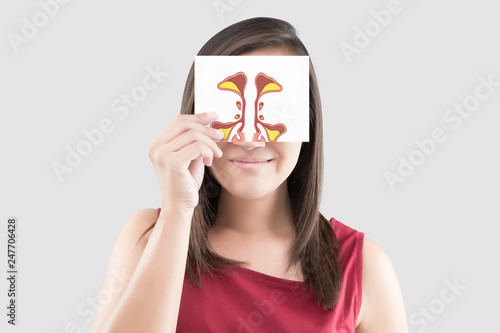 Tableau sur toile Smiling woman hold sinus picture on white paper on the gray background, Portrait