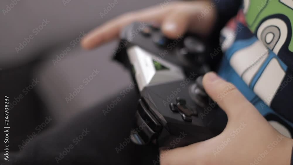 Close-up of boy's hands holding a controller and playing video game Close-up of boy's hands holding a controller and playing video game