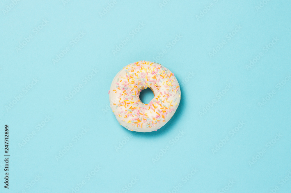 Fresh tasty sweet donut on a blue background. Fast food concept, bakery, breakfast,. Minimalism. Flat lay, top view. Fresh tasty sweet donut on a blue background. Fast food concept, bakery, breakfast,. Minimalism. Flat lay, top view.