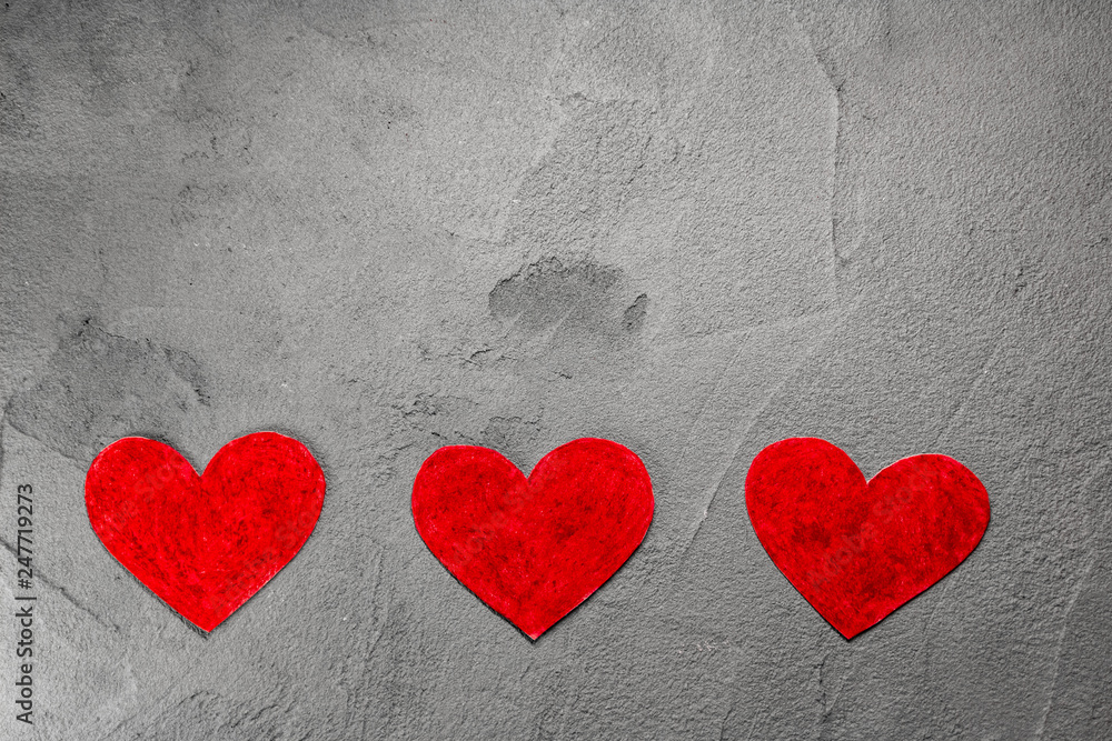 Three Red paper hearts on gray wall with copy space Three Red paper hearts on gray wall with copy space