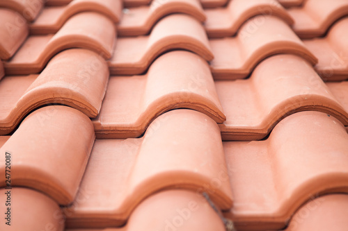 Tiled roof. Beautiful modern orange tile. Close up fragment.