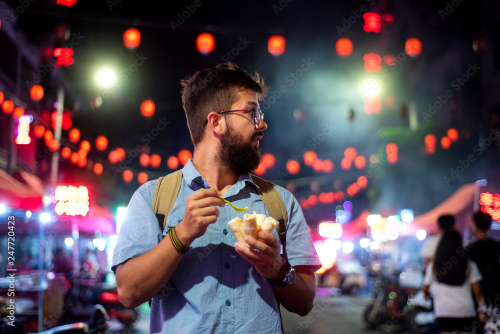 Man having ice cream rolls in the night market Man having ice cream rolls in the night market