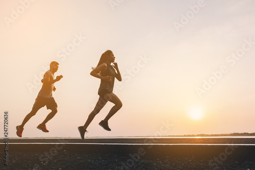 young couple runner running on running road in city park