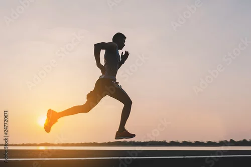 Obraz młody człowiek biegacz działa na drodze w parku miejskim