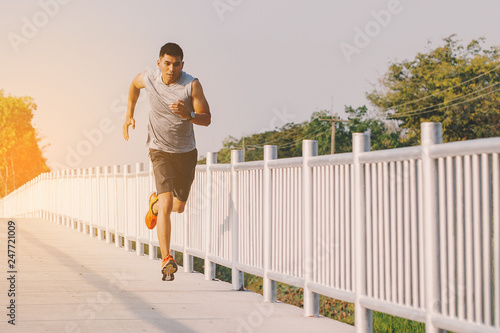 Fototapeta Naklejka Na Ścianę i Meble -  young man runner running on running road in city park