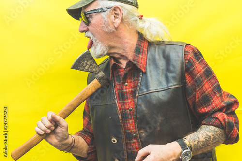 Funny rude woodman on yellow background licking his ax 