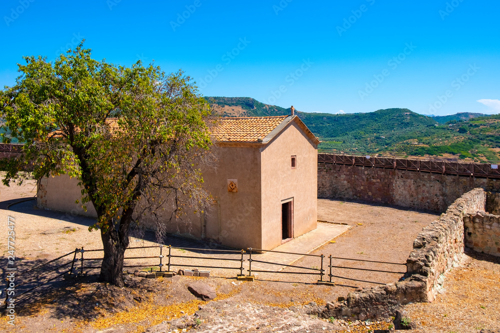 Fototapeta premium Bosa, Sardinia, Italy - The palatine chapel of Malaspina Castle, Castle of Serravalle, known as Church of Our Lady de sos Regnos Altos with the fortress inner courtyard
