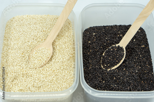 Wooden spoon inside white and black sesame seed. photo