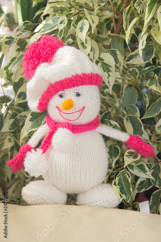 Knitted white snowman with a cheerful smile