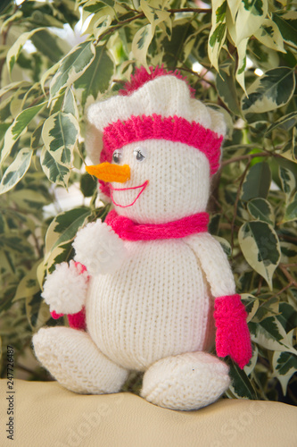 Knitted white snowman with a cheerful smile