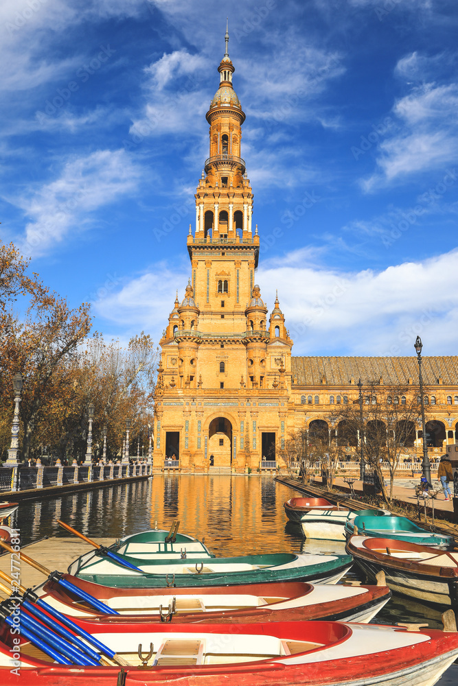 North tower and colorful boats at Spain Square or Plaza de Espana in Seville city, Andalusia, Spain
