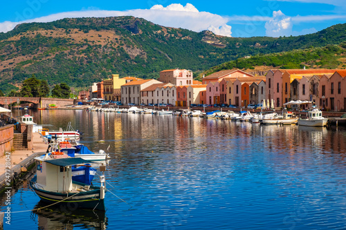 Bosa, Sardinia, Italy - Panoramic view of the old town quarter of Bosa by the Temo river embankment with colorful tenement houses and boats