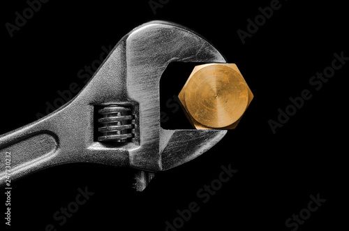 Adjustable wrench with golden plug. Plumbing repair.
