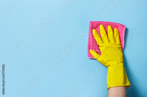 Hand cleaning on a blue background with sponge.