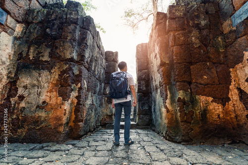 Man backpacker walking inside in Prasat Muang Sing are Ancient ruins of Khmer temple