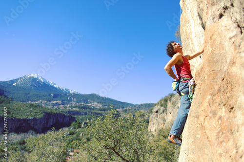 Guy climbing in Greece and beautiful forest and cliff landscape on the background