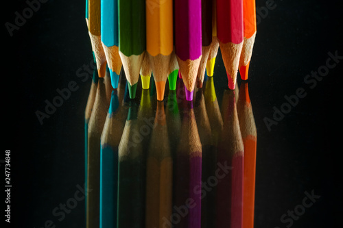 Reflex of color pencils on black background. A lot of colors. photo