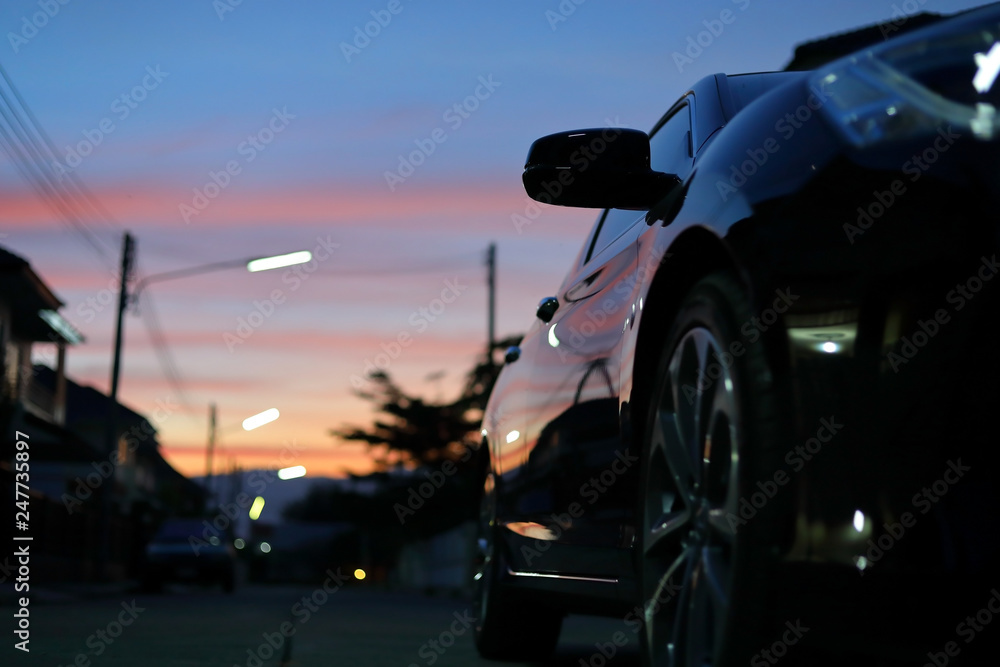 luxury vehicle black car with blur twilight dramatic sky, image selective focus on side mirror luxury vehicle black car with blur twilight dramatic sky, image selective focus on side mirror