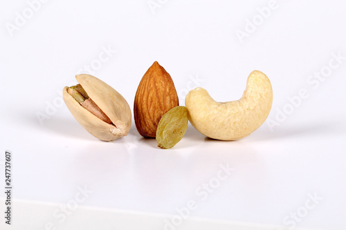 ssorted nuts on white, dry fruits, mix nuts, almond, cashew, pistachio, raisin