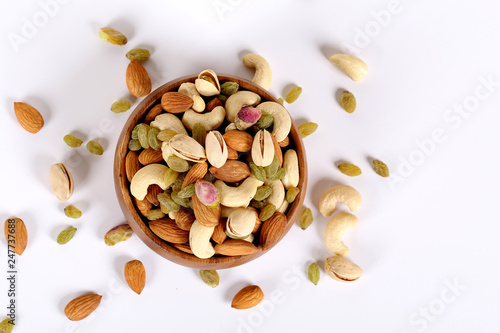 ssorted nuts on white, dry fruits, mix nuts, almond, cashew, pistachio, raisin photo
