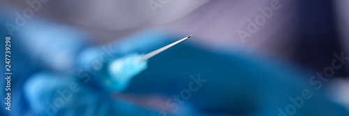 Foto Physician arms wearing protective blue gloves prepare syringe