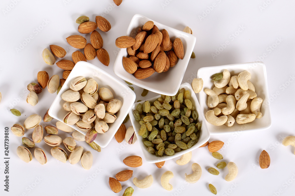 ssorted nuts on white, dry fruits, mix nuts, almond, cashew, pistachio, raisin ssorted nuts on white, dry fruits, mix nuts, almond, cashew, pistachio, raisin