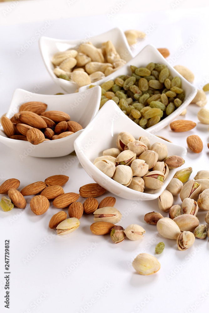 ssorted nuts on white, dry fruits, mix nuts, almond, cashew, pistachio, raisin ssorted nuts on white, dry fruits, mix nuts, almond, cashew, pistachio, raisin
