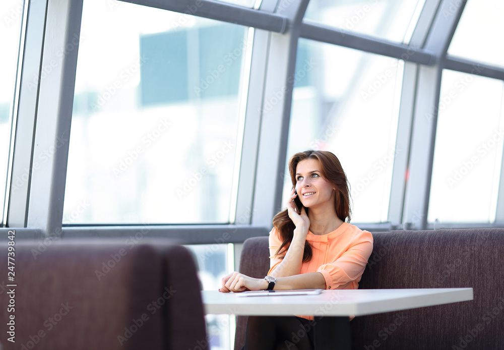 woman consultant with smartphone sitting at her Desk in the office woman consultant with smartphone sitting at her Desk in the office