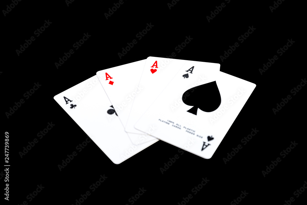 Obraz premium A winning poker hand of four aces playing cards suits on black.