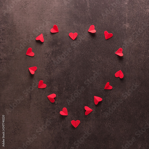 Happy valentines day concept. Bright beautiful heart of small red hearts on dark background