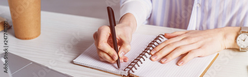 Cropped view of woman writing in notebook photo