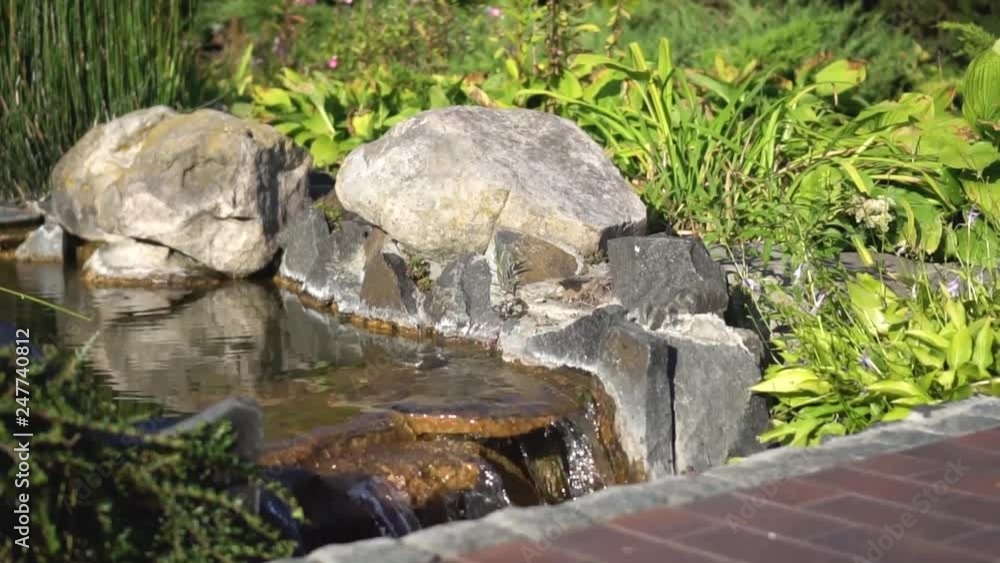 Decorative home waterfall of artificial origin. The landscape of your yard. stock video for art background Decorative home waterfall of artificial origin. The landscape of your yard. stock video for art background