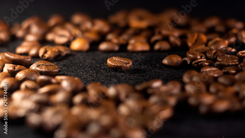 Focus on a single coffee bean on a background of many grains of coffee